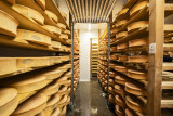 Vue d'ensemble de la cave avec étagères remplies de fromages Abondance