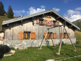 Façade du chalet avec balançoire pour les enfants