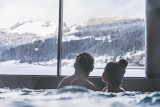 Couple qui admire la vue du village enneigé depuis le bassin du spa Océane