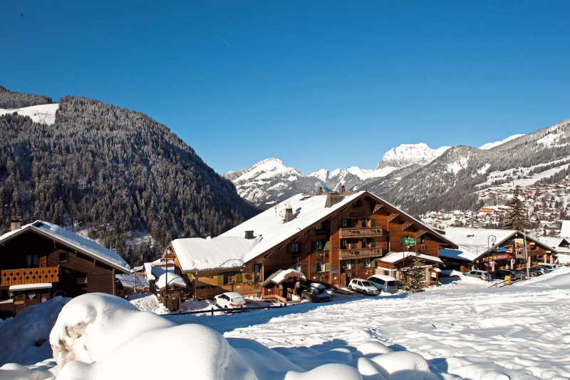 Vue de l'hôtel sous la neige avec les montagnes en arrière-plan