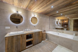 Très grande salle de bains, double vasque avec son meuble en bois,  plafond en bois, grande baignoire