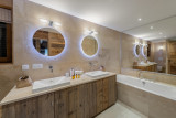 Double vasque avec meuble en bois, miroirs ronds, grande baignoire