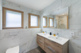 Salle de bains avec double vasque et son meuble, grand miroir, deux fenêtres