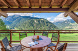 Terrasse couverte avec son mobilier et vue panoramique sur le village et les montagnes