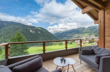 Balcon terrasse avec son mobilier de jardin et vue panoramique sur le village et les montagnes