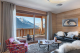 Coin salon avec fauteuils, canapés, grand balcon terrase, vue sur les montagnes