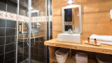 Salle de bains avec douche, vasque simple avec son meuble en bois, miroir