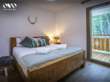 Chambre double avec son grand lit une porte fenêtre donnant accès au balcon et vue sur les montagnes