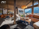 Vue du séjour et salle à manger avec grandes baies vitrées donnant sur le balcon, vue sur les montagnes