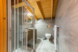 Salle de bains avec douche, toillettes, sèche serviettes, vasque