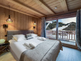 Chambre double avec grande baie vitrée donnant accès au balcon, vue sur les pistes du Linga