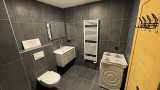 Salle de bains avec toilettes, vasque et meuble, sèche-serviette, machine à laver
