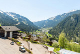 Vue depuis l'appartement sur les montagnes et le village, parking au pied de la résidence