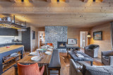 Espace salle à manger dans pièce à vivre ouverte, grande table avec bancs et fauteuil, cheminée