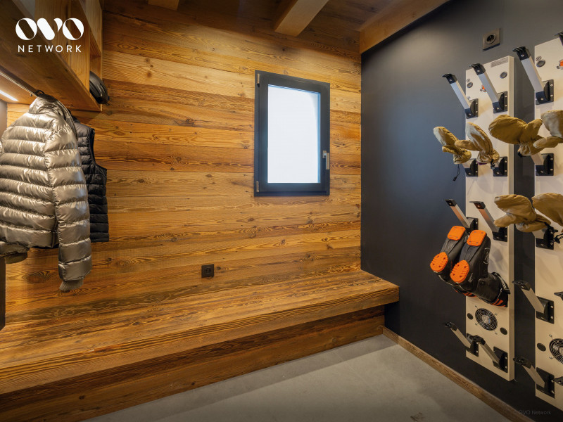 Local à skis avec sèche-chaussures, bancs, porte manteaux, fenêtre